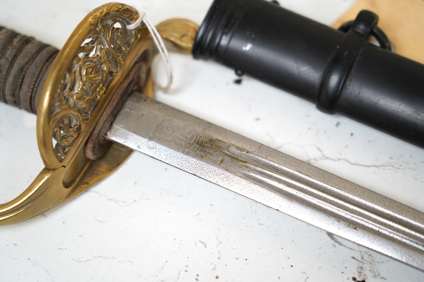 A German (Saxon) infantry officer's sword and scabbard, c.1900, with triple fullered blade, engraved with the cypher of Frederick August II, regulation brass hilt with folding side guard, in its steel scabbard, blade 80c